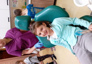 Dziewczynka wygodnie siedzi na fotelu dentystycznym